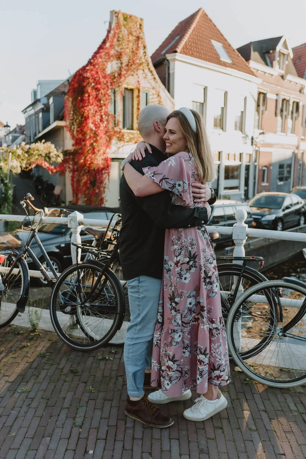 Couple getting engaged, they are hugging on a bridge next to bicycles in a street in Haarlem, the Netherlands