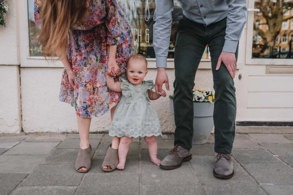 Mom and dad standing with their baby girl