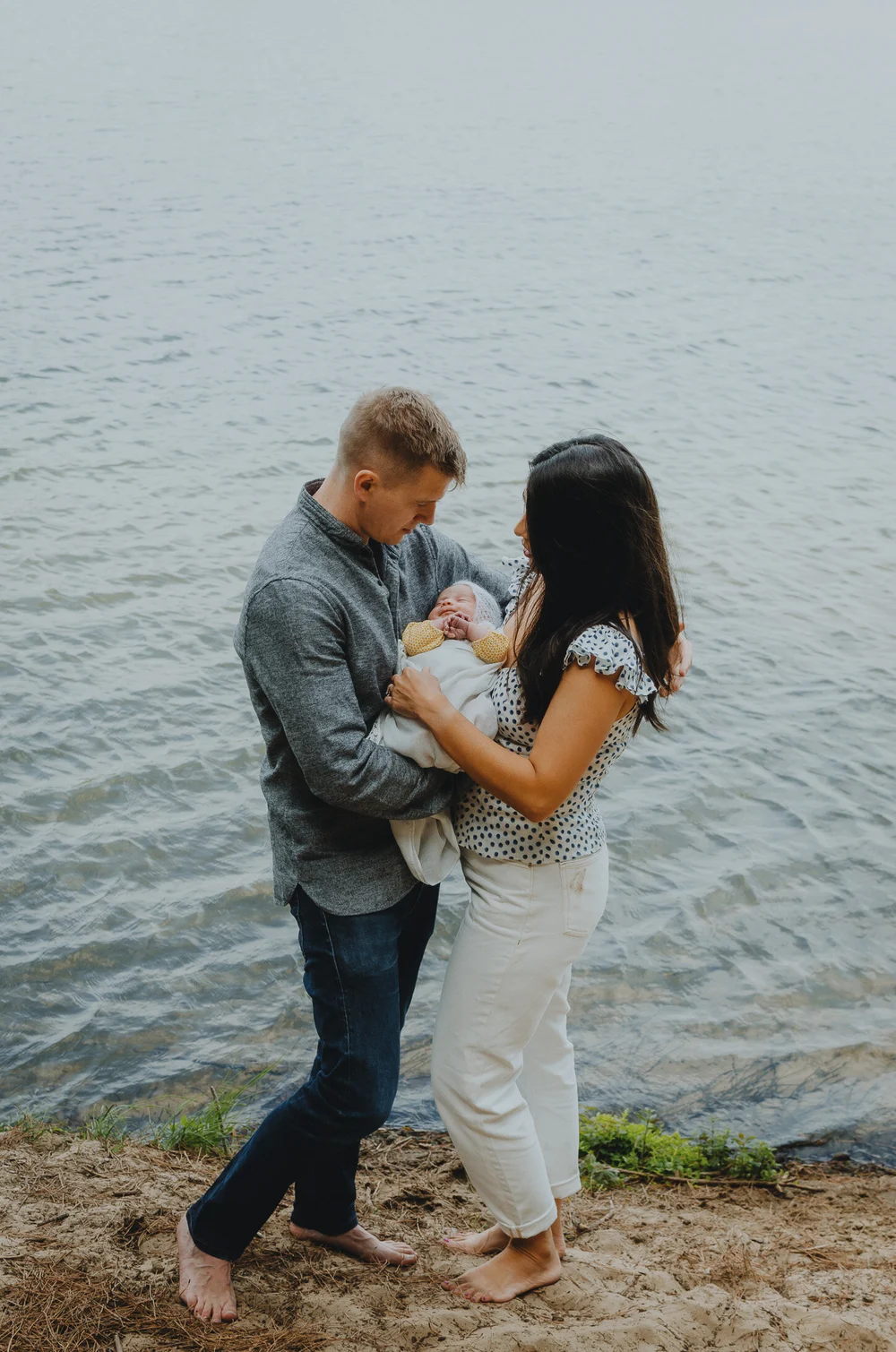 Mom and dad holding onto their newborn baby