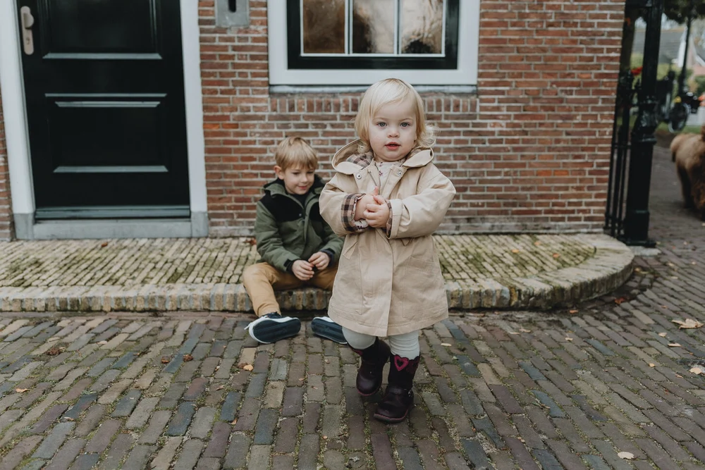 Family photoshoot with brother and sister sitting in a street in Spaarndam
