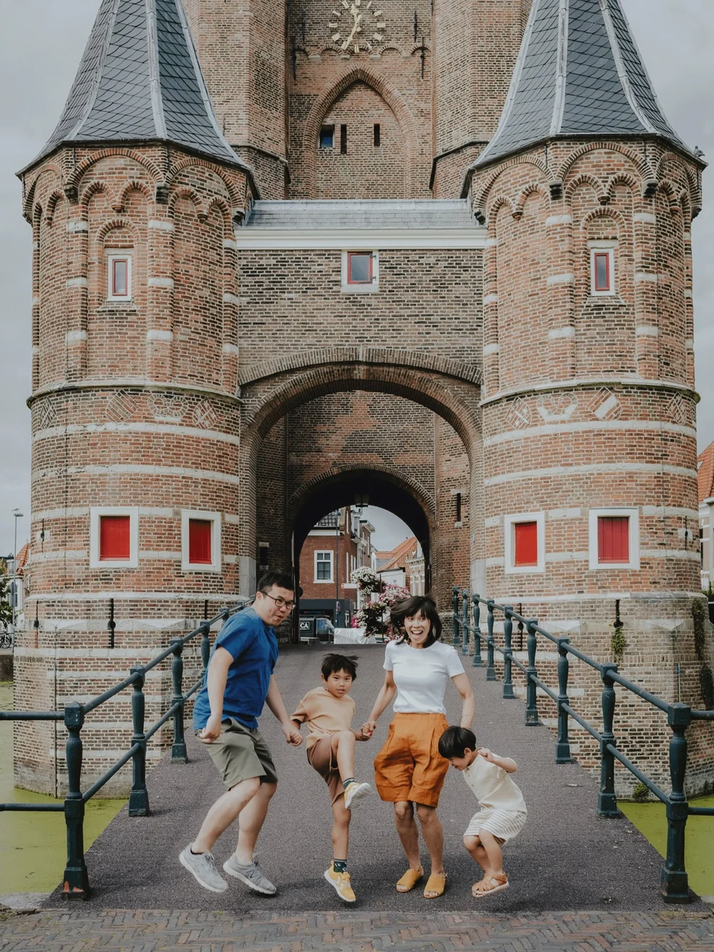 Asian Family from Denmark running and playing while on holiday in Haarlem in front of the Amsterdamse Poort
