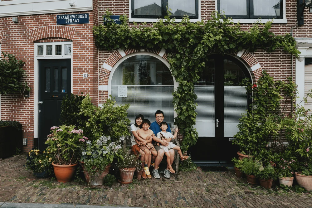 Family sitting in front of a house in Haarlem, they are in holiday in Haarlem.